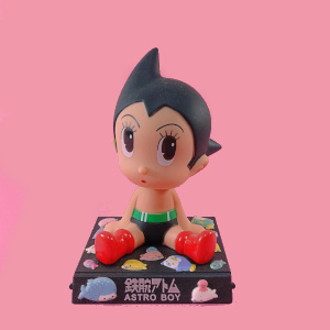 bobblehead japonês astro boy não licenciado. a base é decorada com adesivos do mamegoma